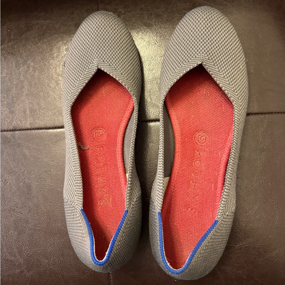Rothy's gray knit flats with red insoles and blue heel trim